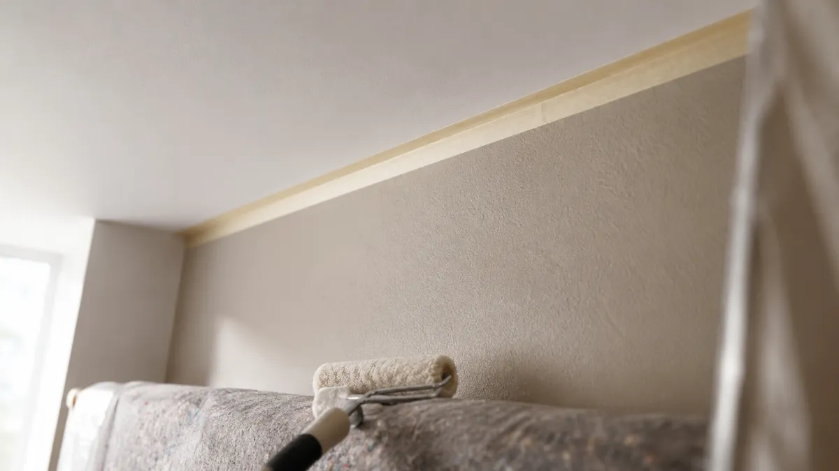 Abgeklebter Übergang zwischen Decke und Wand mit Farbrolle auf geschützter Fläche