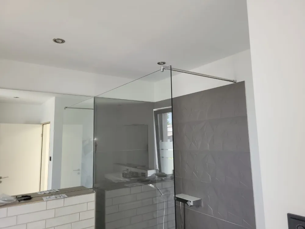 Modernes Badezimmer mit grauer Akzentwand und sauber gestrichener weißer Decke