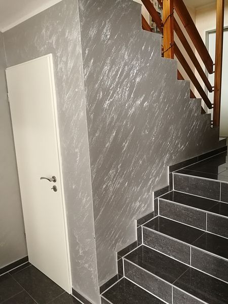 Veredelte Wandfläche im Treppenhaus mit grauer Strukturtechnik